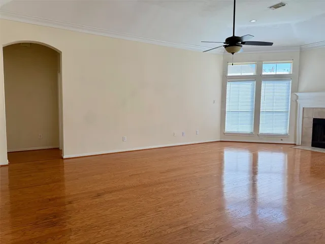 a view of an empty room with a window and wooden floor