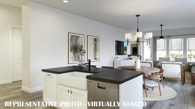 a kitchen with a table chairs and white cabinets