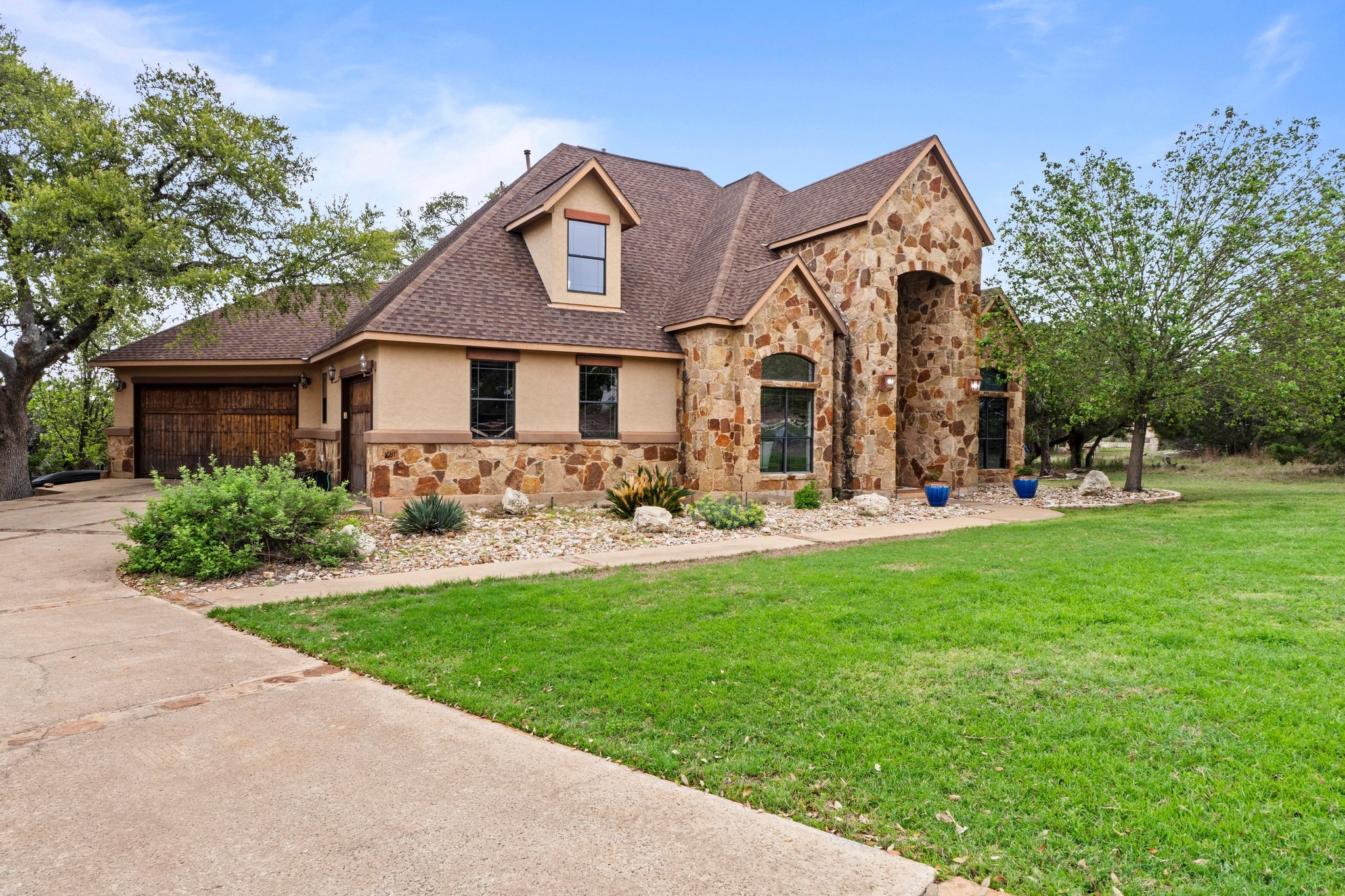 8211 Moon Rise Trail Jonestown, TX 78645 - Photo 1 of 34 Offers a spacious driveway with a side entry garage. 3 garage bays with wood garage doors.