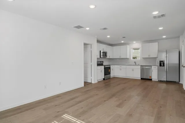 a kitchen with white cabinets sink and stainless steel appliances