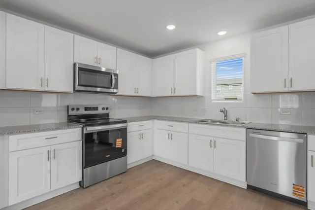 a kitchen with stainless steel appliances granite countertop white cabinets and black appliances