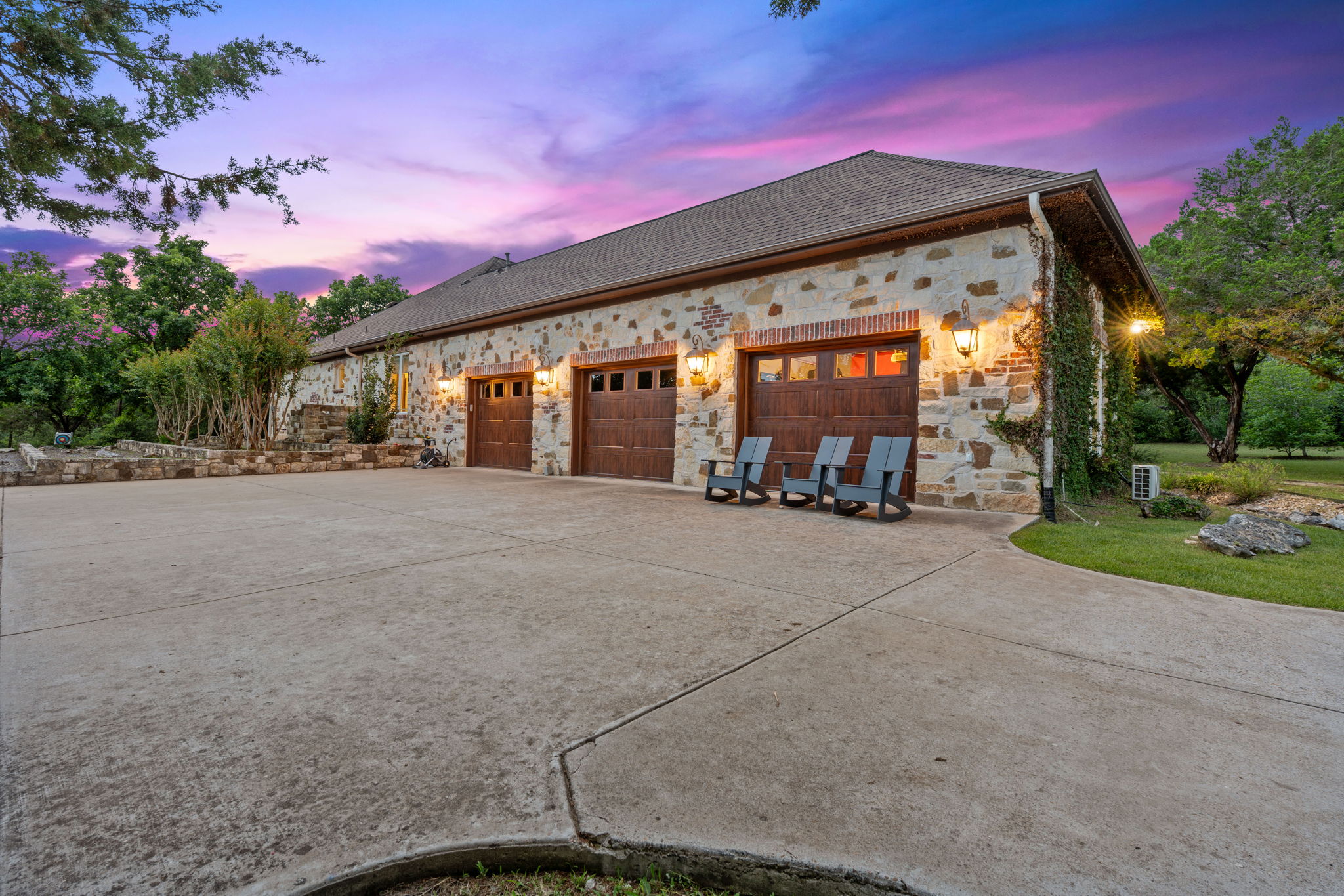 8121 Bluff Trail Austin, TX 78737 - Photo 29 of 40 A grand, multi-car garage with stone and brick details offers ample parking and curb appeal.
