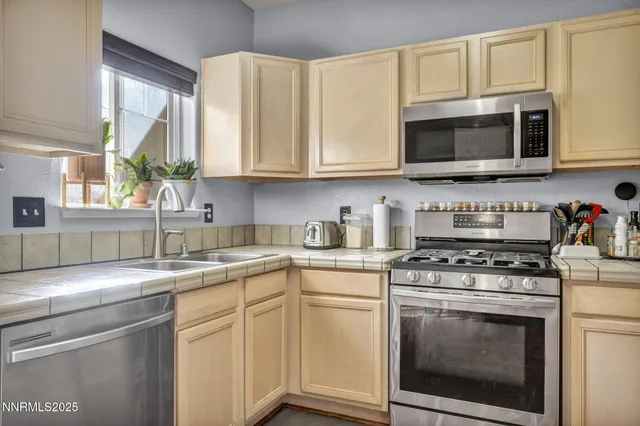 a kitchen with stainless steel appliances granite countertop white cabinets a sink and a stove