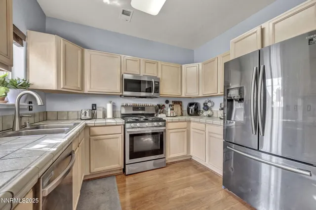 a kitchen with cabinets stainless steel appliances and a sink