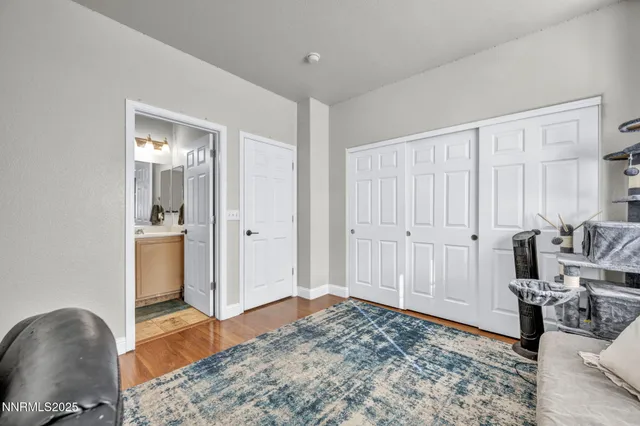 a view of a bedroom with a bed and wooden floor
