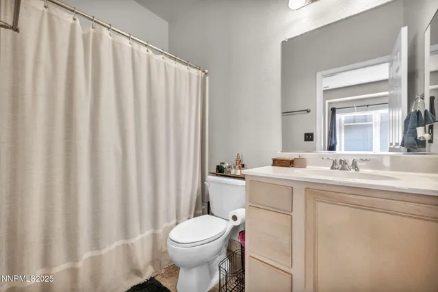 a bathroom with a sink a toilet and shower curtain