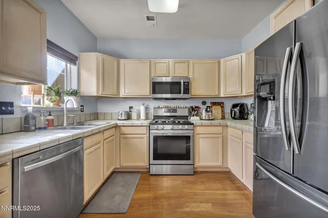 a kitchen with cabinets stainless steel appliances and a window