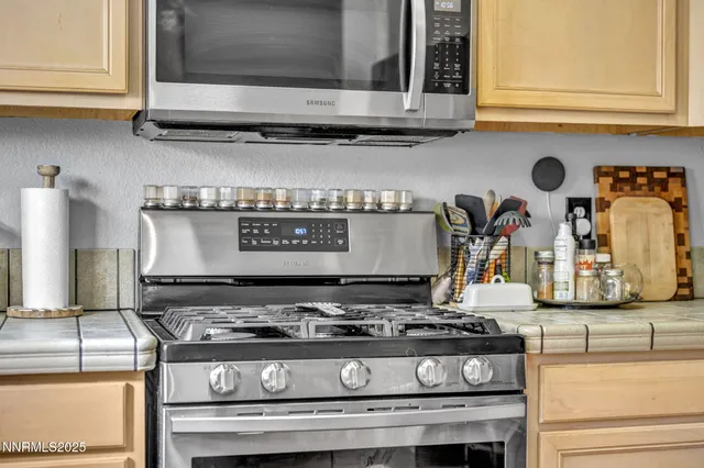 a stove sitting inside of a kitchen with granite countertop stainless steel appliances