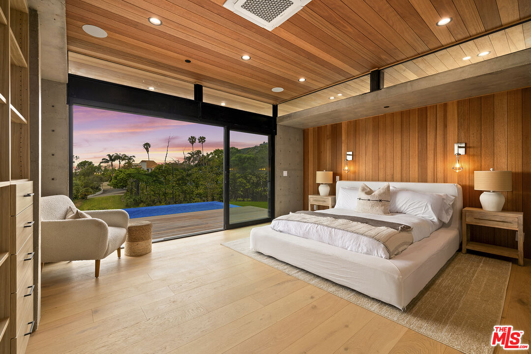 5707 Busch Drive Malibu, CA 90265 - Photo 15 of 35 a spacious bedroom with a large bed and a balcony