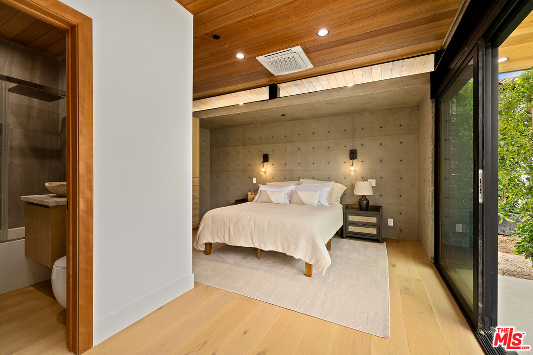 5707 Busch Drive Malibu, CA 90265 - Photo 20 of 35 a bedroom with a bed and wooden floor