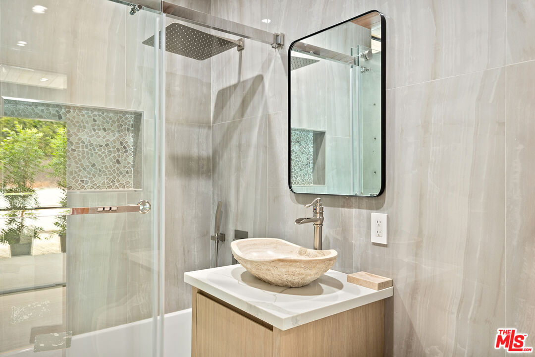 5707 Busch Drive Malibu, CA 90265 - Photo 21 of 35 a bathroom with a sink a mirror and a shower