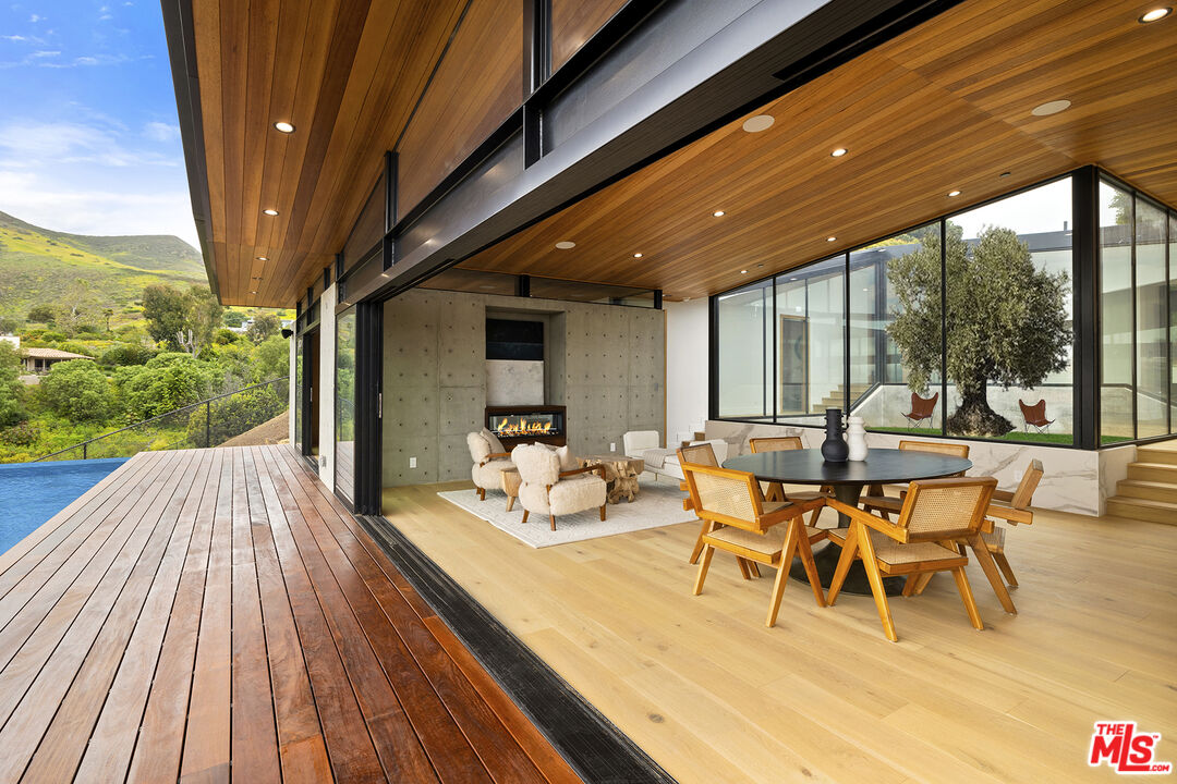 5707 Busch Drive Malibu, CA 90265 - Photo 4 of 35 a view of a patio with table and chairs and wooden floor