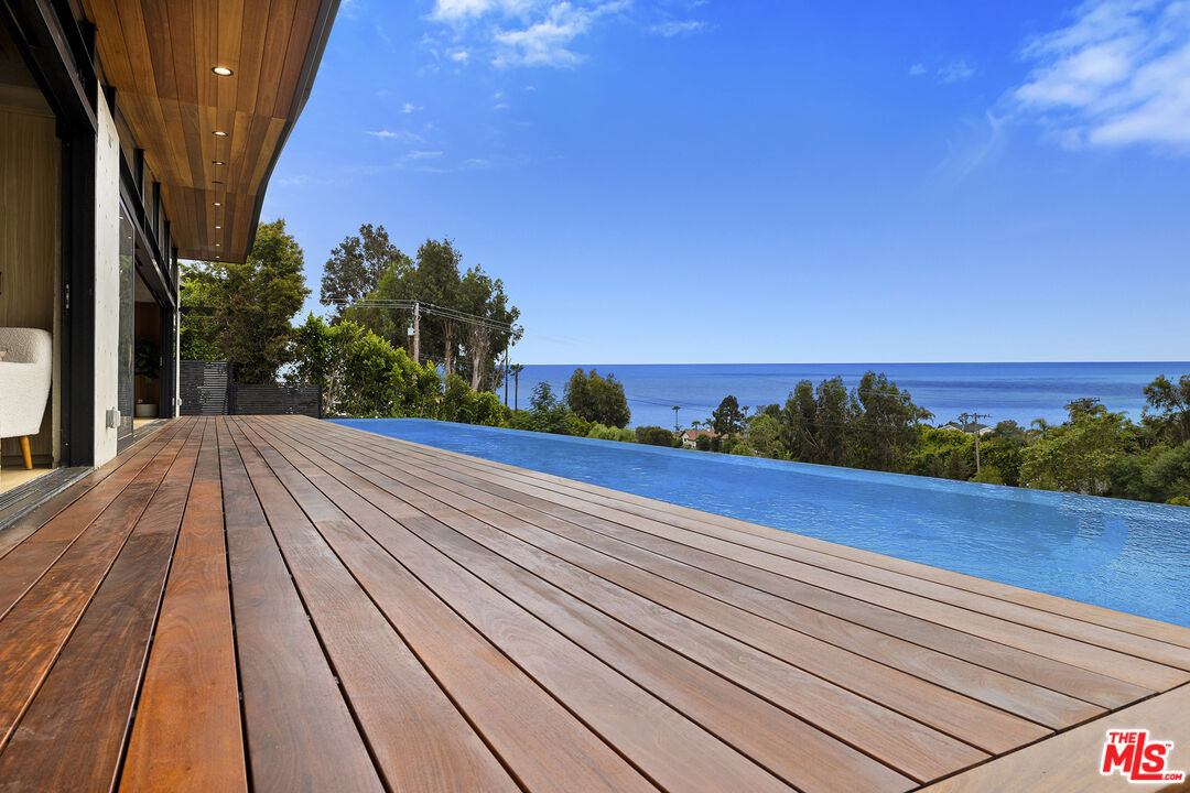 5707 Busch Drive Malibu, CA 90265 - Photo 6 of 35 a view of a balcony with wooden floor and a potted plant