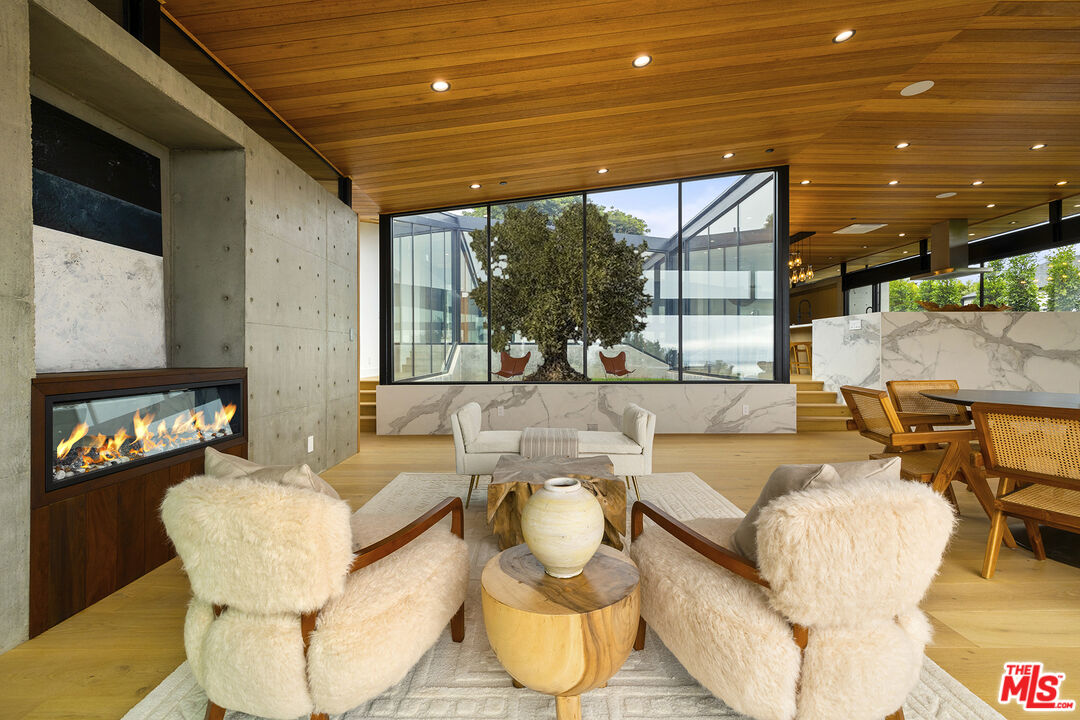 5707 Busch Drive Malibu, CA 90265 - Photo 7 of 35 a living room with fireplace furniture and a floor to ceiling window