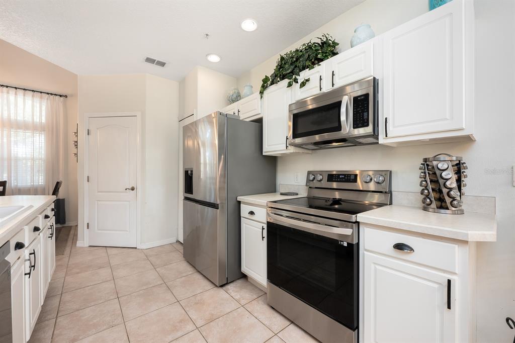 700 Seabrook Court, Unit 201 Altamonte Springs, FL 32714 - Photo 11 of 32 a kitchen with stainless steel appliances granite countertop a stove a refrigerator and a microwave