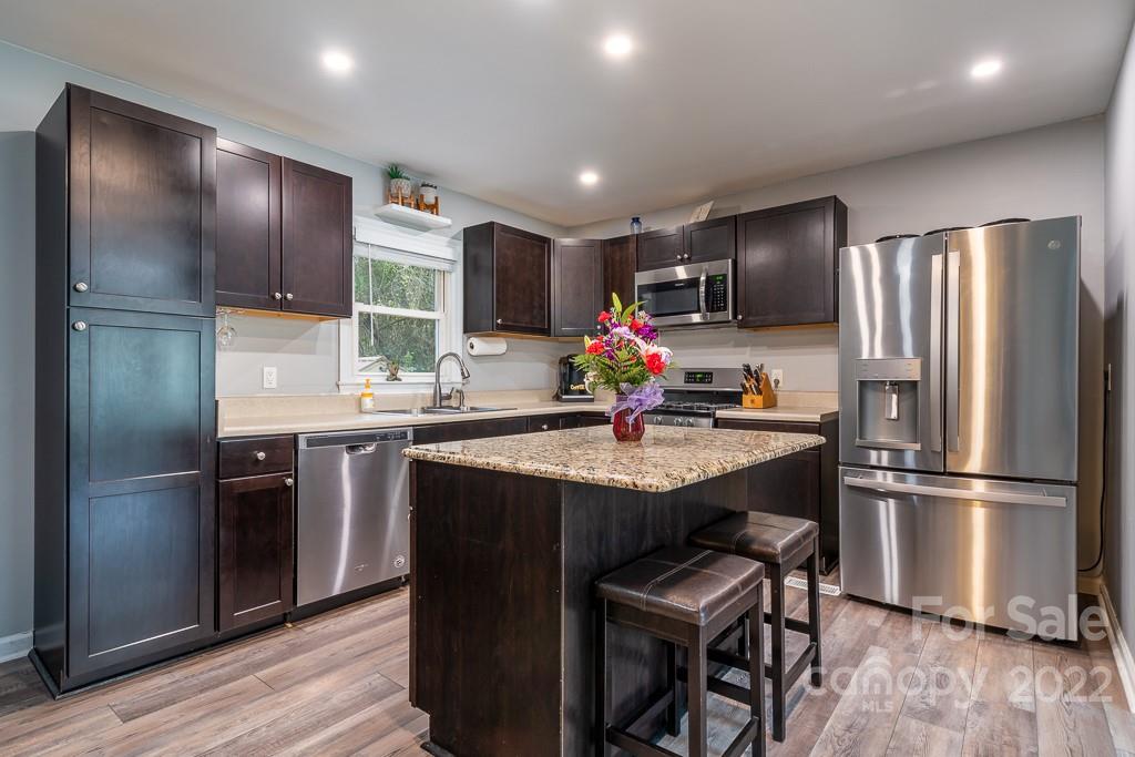 626 Westside Terrace, Unit 5 Davidson, NC 28036 - Photo 8 of 24 a kitchen with stainless steel appliances granite countertop a refrigerator a stove a sink and a refrigerator
