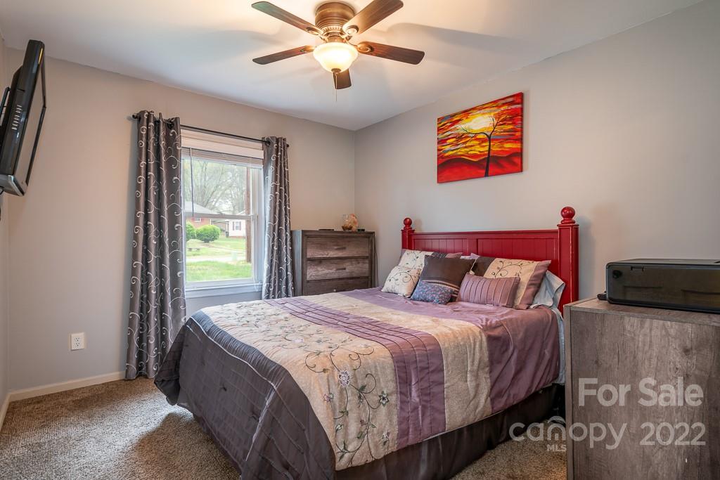 626 Westside Terrace, Unit 5 Davidson, NC 28036 - Photo 10 of 24 a bedroom with a bed and a chandelier