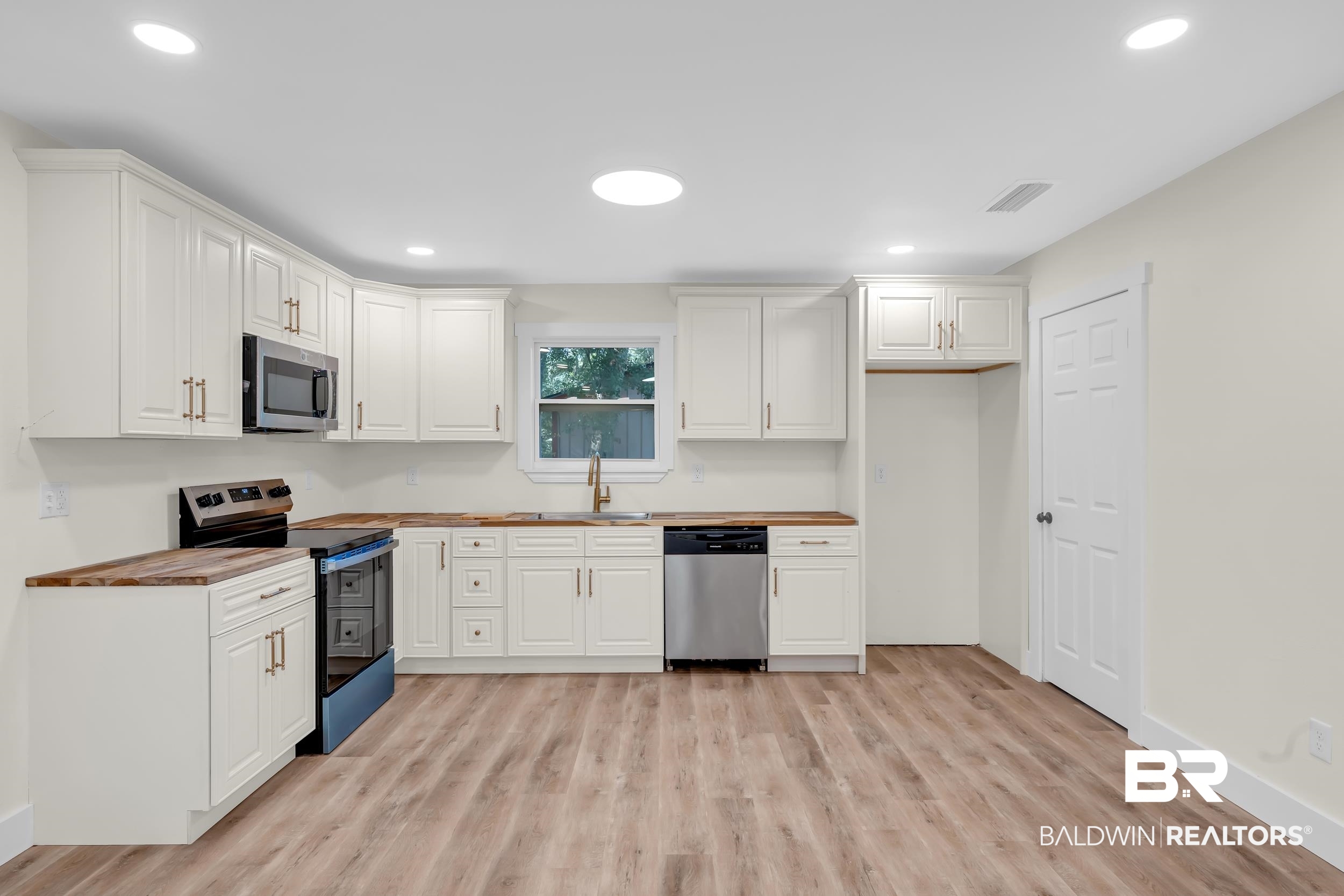 5109 McDonald Road Theodore, AL 36582 - Photo 7 of 21 Modern kitchen featuring white shaker cabinetry and wood-finish countertops