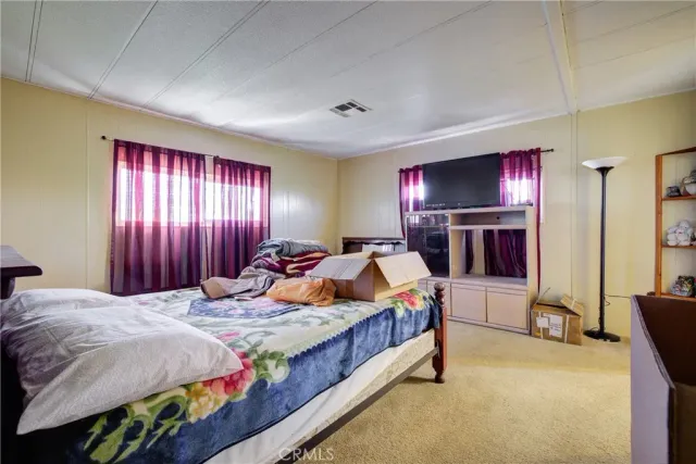 a bedroom with bed and a flat screen tv