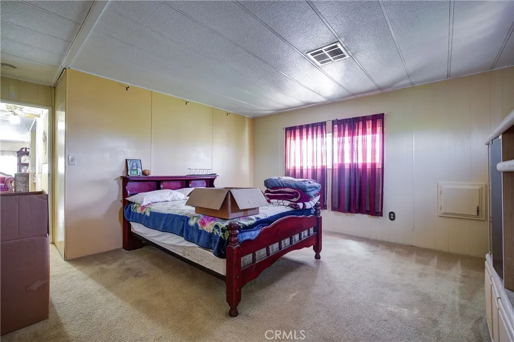 3700 Buchanan Street, Unit 180 Riverside, CA 92501 - Photo 16 of 23 a bedroom with a bed and a chandelier