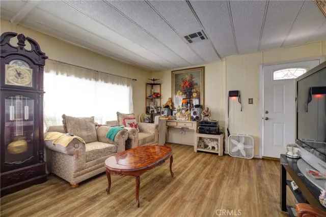 a living room with furniture a flat screen tv and a wooden floor