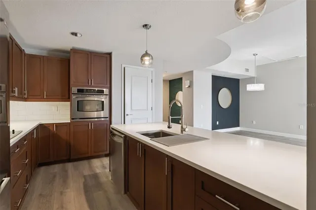 a kitchen with a sink and a stove top oven with wooden floor