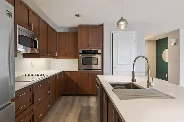 a kitchen with stainless steel appliances a stove a sink cabinets and a refrigerator