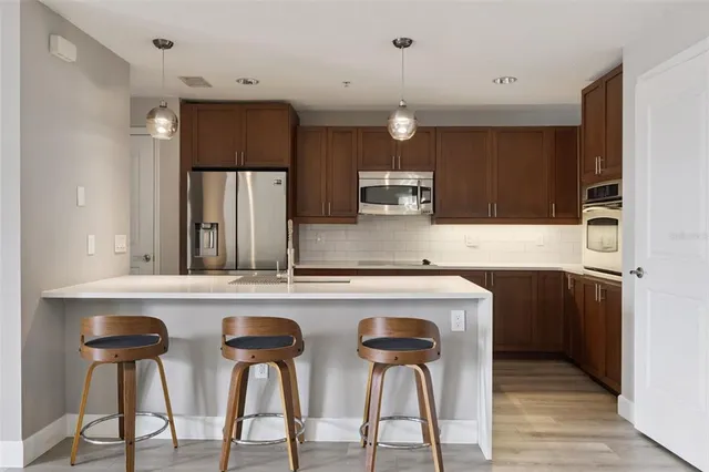 a kitchen with stainless steel appliances granite countertop a sink and a refrigerator