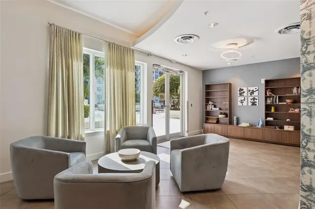 a living room with couches and kitchen view with wooden floor
