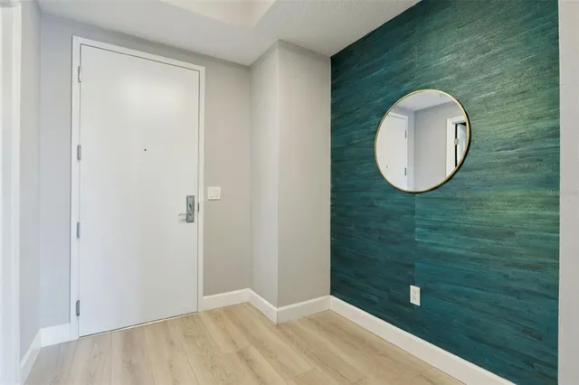 an empty room with wooden floor and window