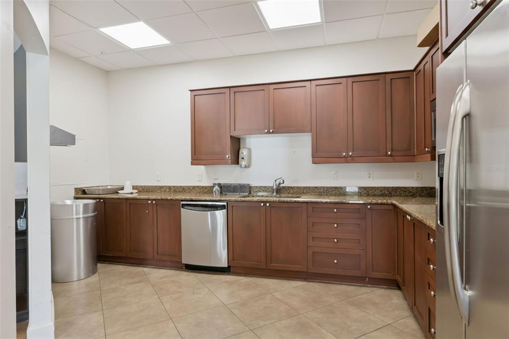 100 South Eola Drive, Unit 911 Orlando, FL 32801 - Photo 51 of 53 a kitchen with granite countertop a refrigerator and a sink