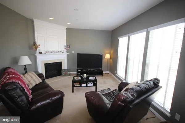 a living room with furniture a large window and a fireplace