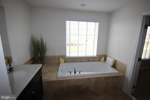 a bathroom with a tub sink and mirror