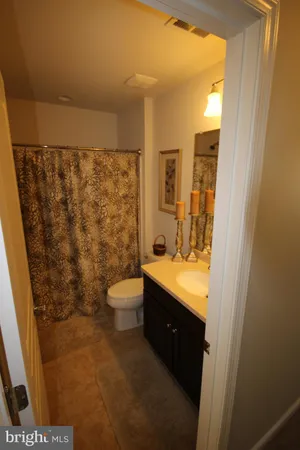 a bathroom with a granite countertop sink a toilet and shower