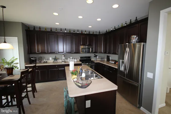 a kitchen with granite countertop stainless steel appliances a refrigerator a stove a sink and a center island
