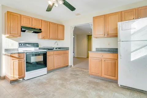 a kitchen with stainless steel appliances granite countertop a stove a sink and a refrigerator
