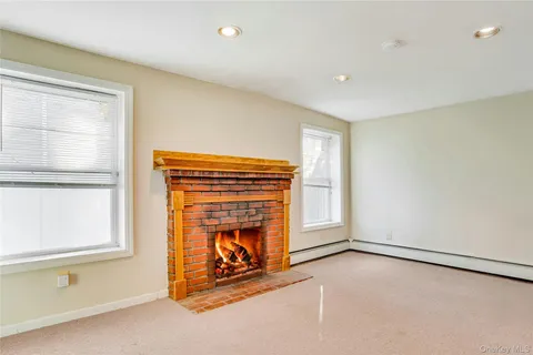 a view of an empty room with a fireplace and a window