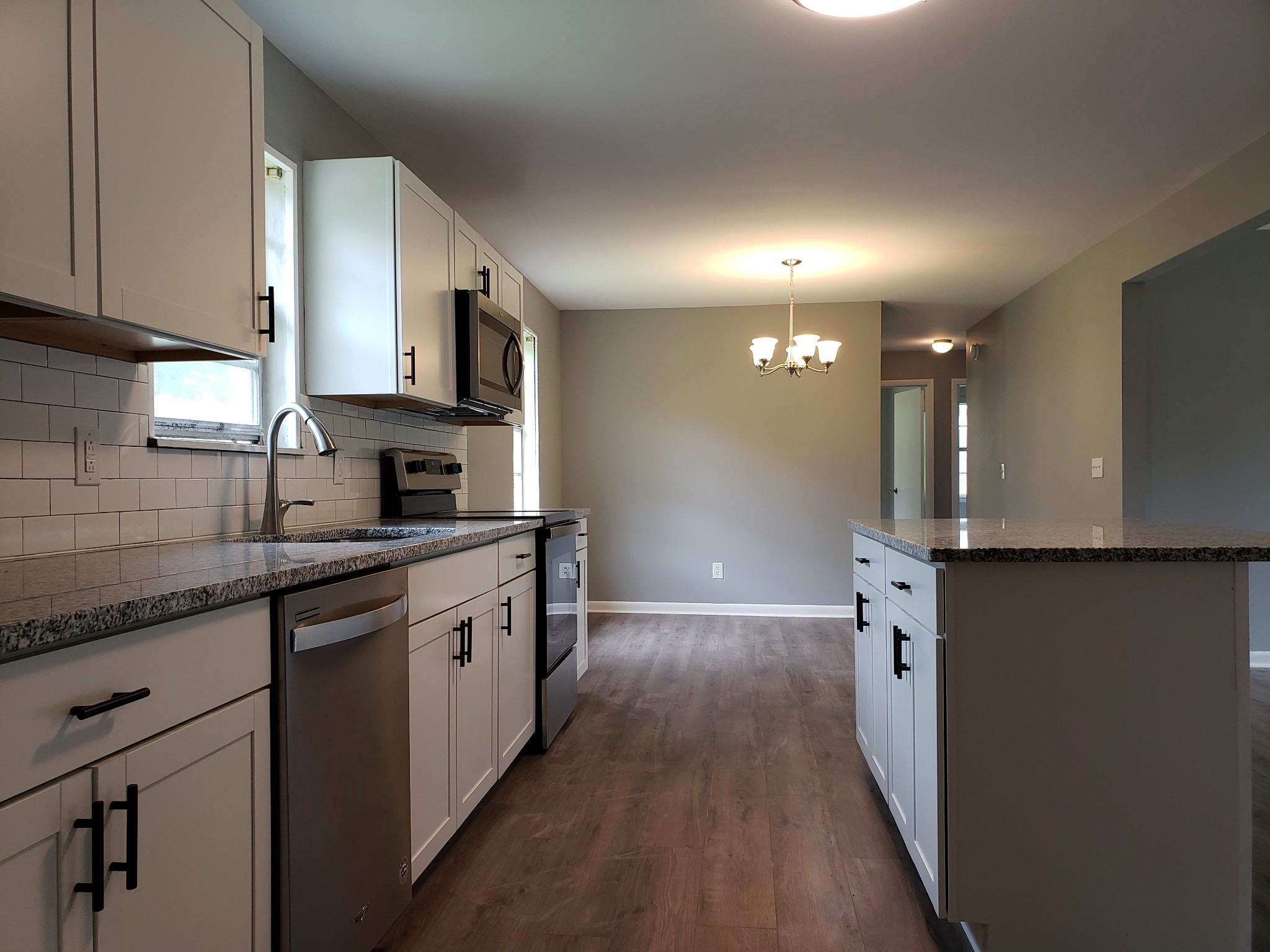 814 Miles Road Pulaski, TN 38478 - Photo 13 of 35 a kitchen with granite countertop a sink a stove top oven and cabinets