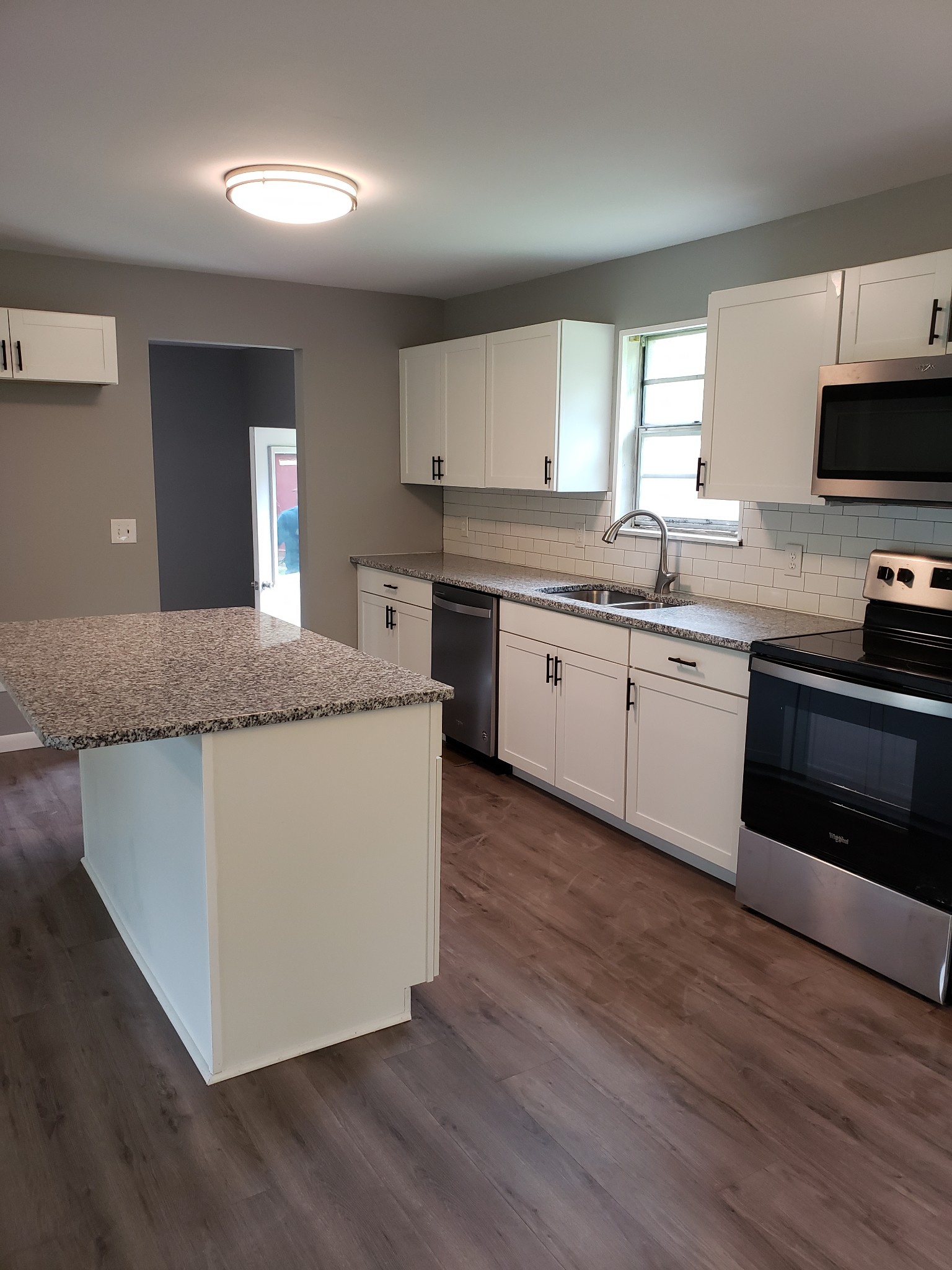 814 Miles Road Pulaski, TN 38478 - Photo 14 of 35 a kitchen with stainless steel appliances granite countertop a stove a sink and a microwave
