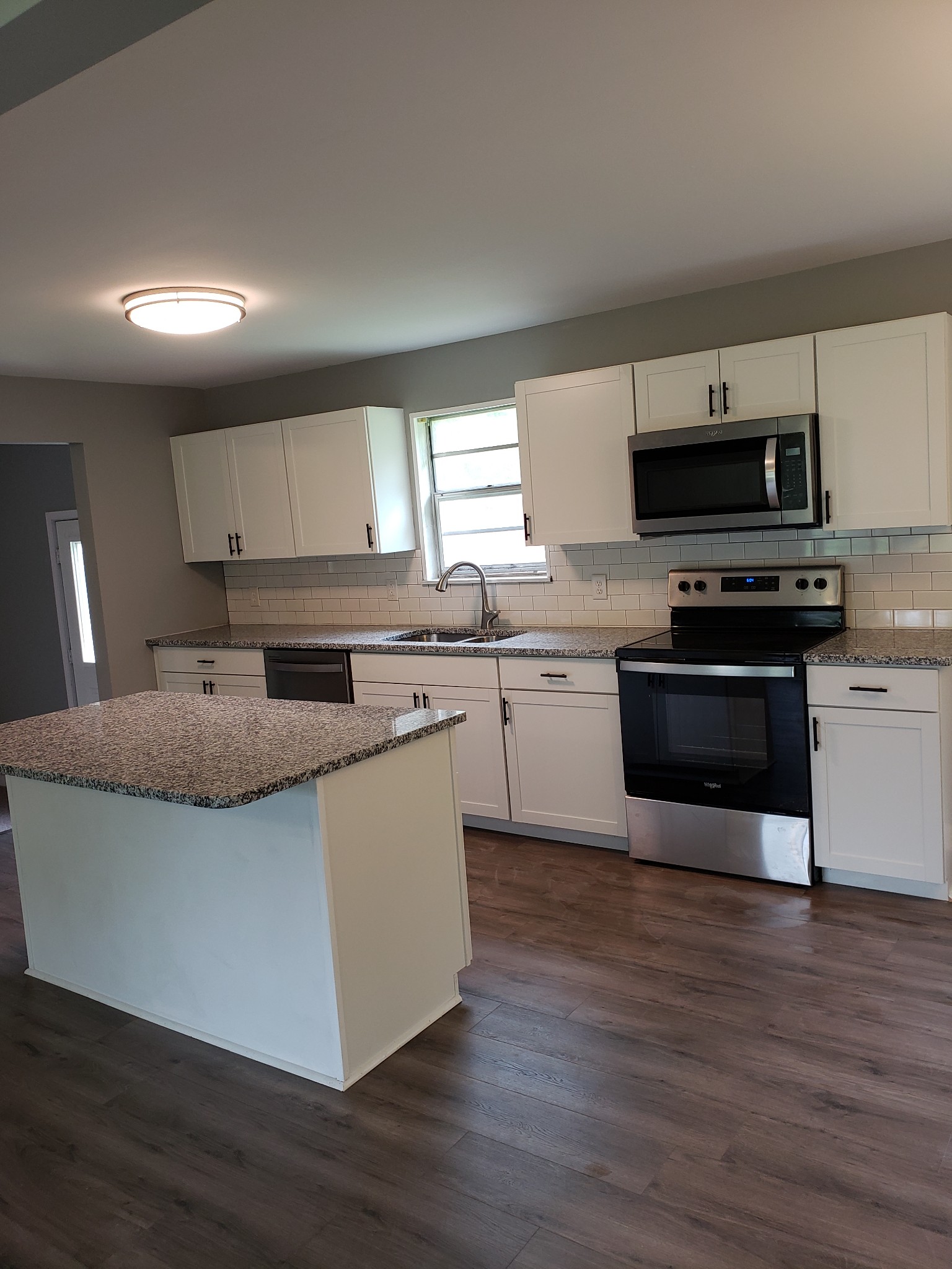 814 Miles Road Pulaski, TN 38478 - Photo 15 of 35 a large kitchen with stainless steel appliances granite countertop a stove a sink a microwave a refrigerator and white cabinets