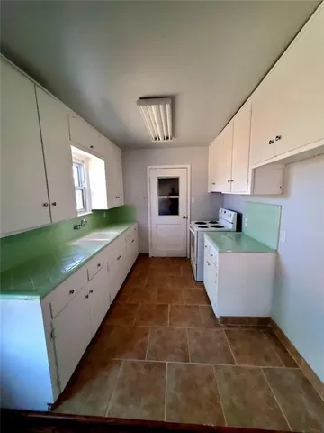 a large kitchen with kitchen island granite countertop a sink and a stove