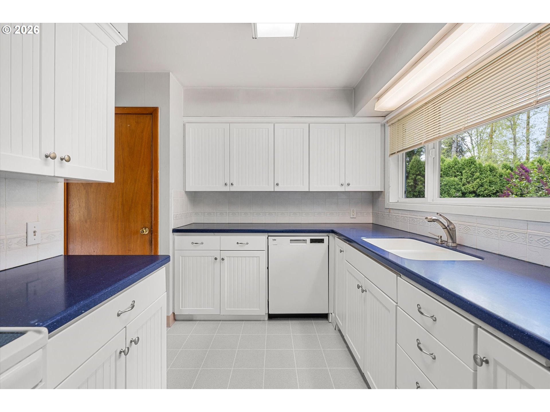 3235 Southeast Silver Springs Road Milwaukie, OR 97222 - Photo 11 of 32 a kitchen with granite countertop white cabinets white appliances a sink and a large window