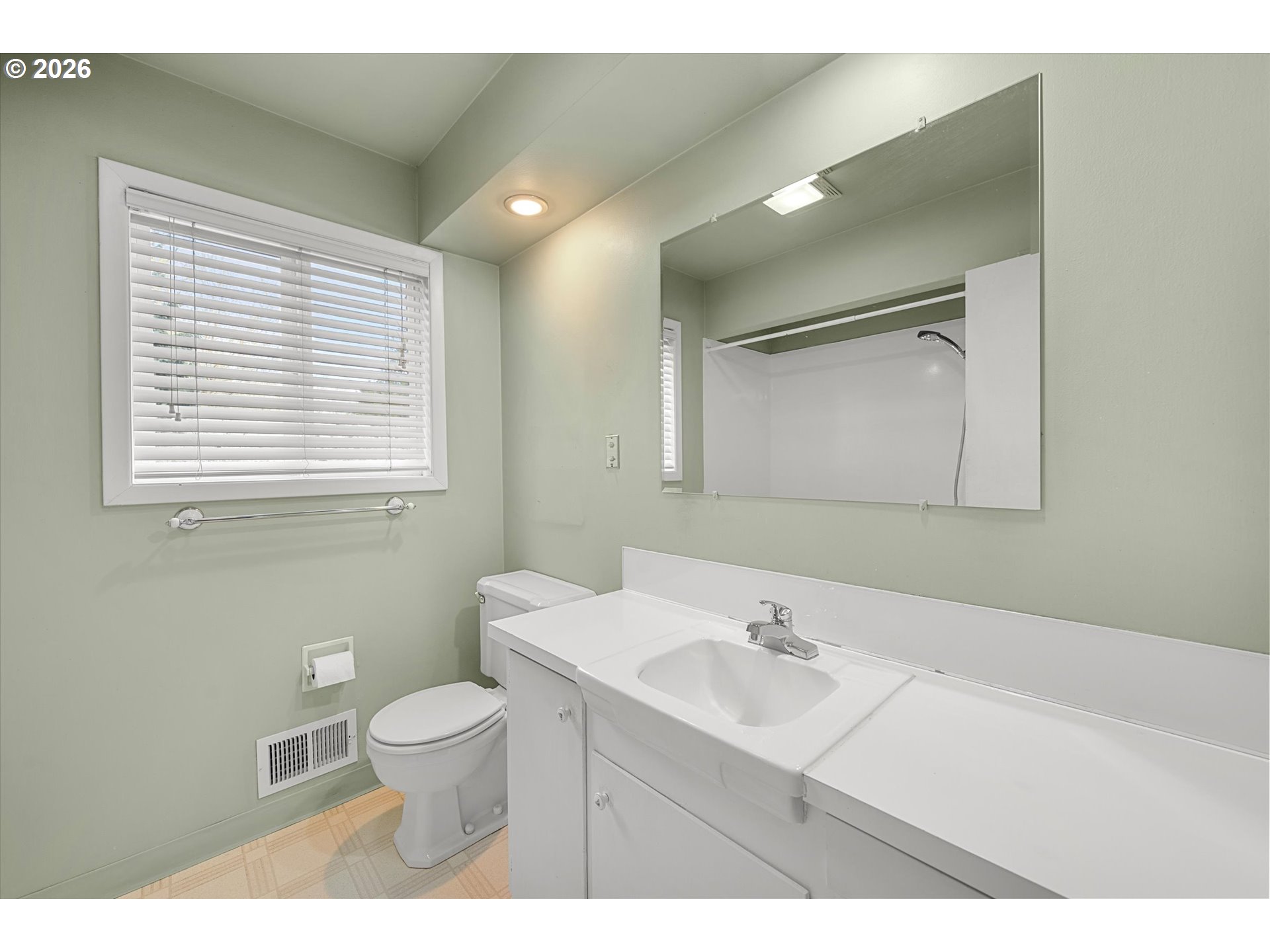 3235 Southeast Silver Springs Road Milwaukie, OR 97222 - Photo 21 of 32 a bathroom with a sink a toilet a mirror and a window