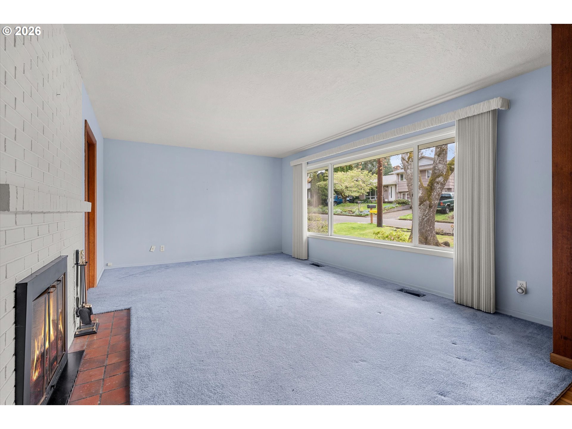 3235 Southeast Silver Springs Road Milwaukie, OR 97222 - Photo 6 of 32 a view of an empty room with a fireplace and a window