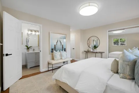 a large bed sitting in a bedroom next to a window