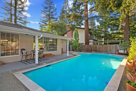 a view of a house with a swimming pool and sitting area