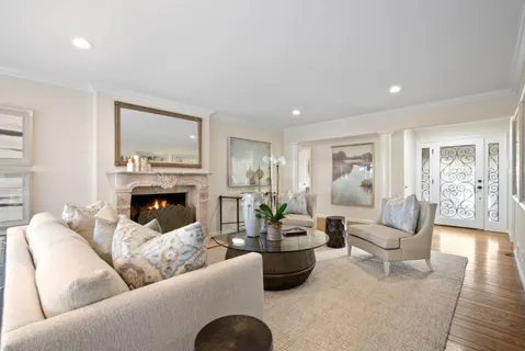 a dining room with furniture a chandelier and wooden floor