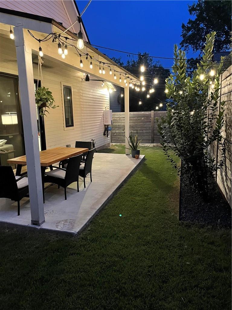 2002 East 9th Street, Unit 2 Austin, TX 78702 - Photo 22 of 32 An inviting concrete patio provides a serene setting for evening relaxation or entertaining under string lights.