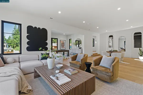a living room with furniture kitchen view and a window