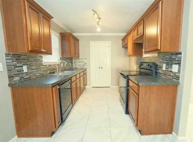 a kitchen with stainless steel appliances granite countertop a stove a sink dishwasher and a refrigerator